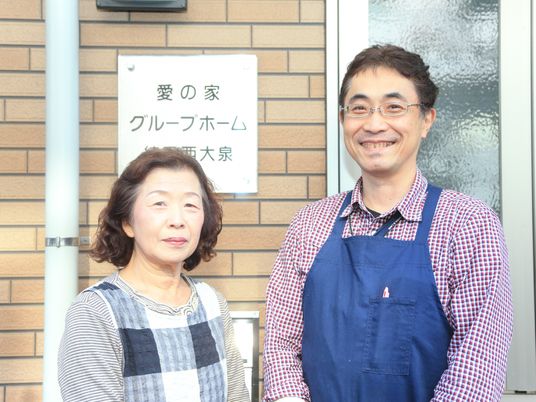 笑顔の男女と案内看板