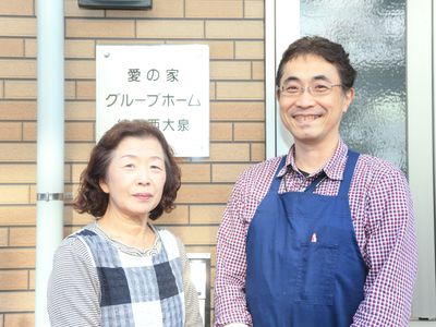 笑顔の男女と案内看板