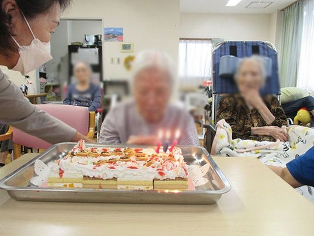 誕生日ケーキの提供場面 ラウンジ 居住者が集まり、誕生日をお祝いする温かな雰囲気です。日常の大切なひとときを支えます。