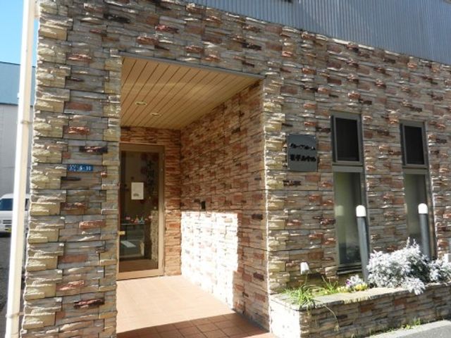 穏やかなエントランス風景 エントランス 石積みの壁が印象的なエントランスです。暖かな光が差し込む、迎える空間となっております。
