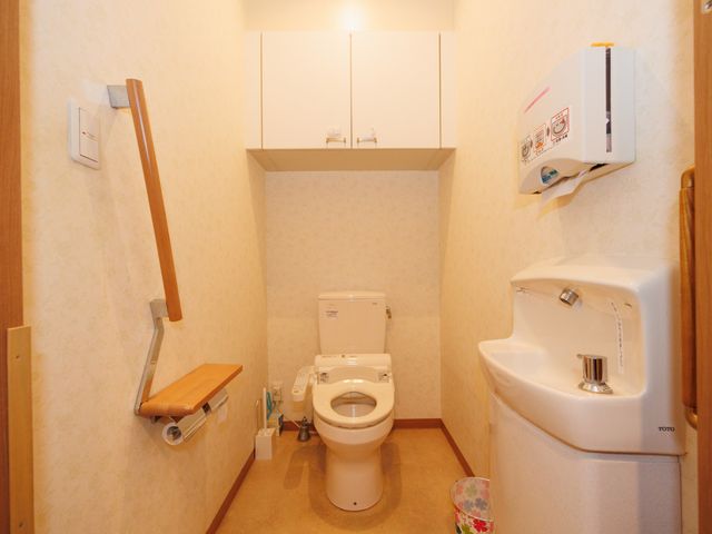 快適なトイレの設備 トイレ 手すり付きで広々としているトイレは、働く環境の良さを感じさせます。清潔で安全な空間です。