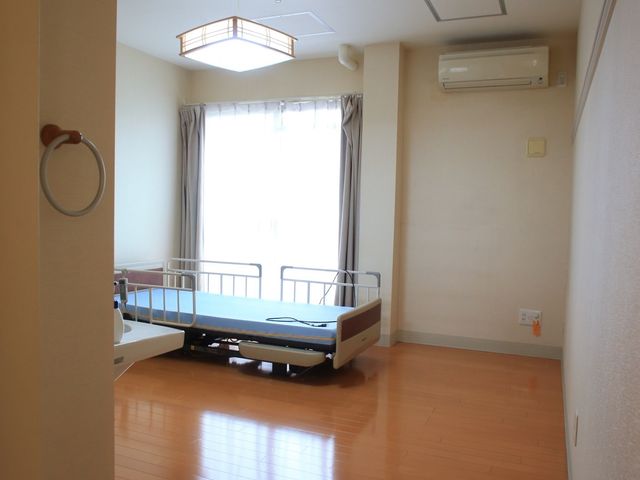 明るい洋室の居室 居室 広々とした居室では、日当たりが良く快適なひとときをお過ごしいただけます。機能的なベッドも完備しており、快適な生活空間を提供しています。