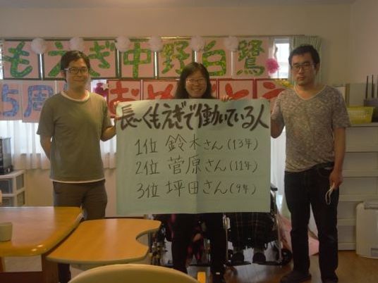 掲示物の前の3人  