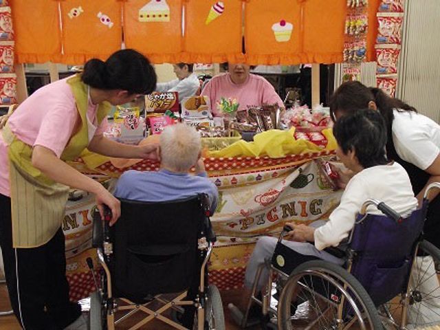 和やかな食堂の様子 食堂 明るい雰囲気の中で、スタッフが丁寧にサービスを提供している様子が伺えます。利用者同士のコミュニケーションも活発です。