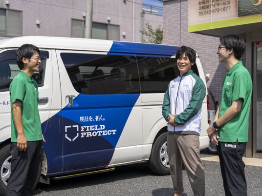 送迎車前のスタッフ  