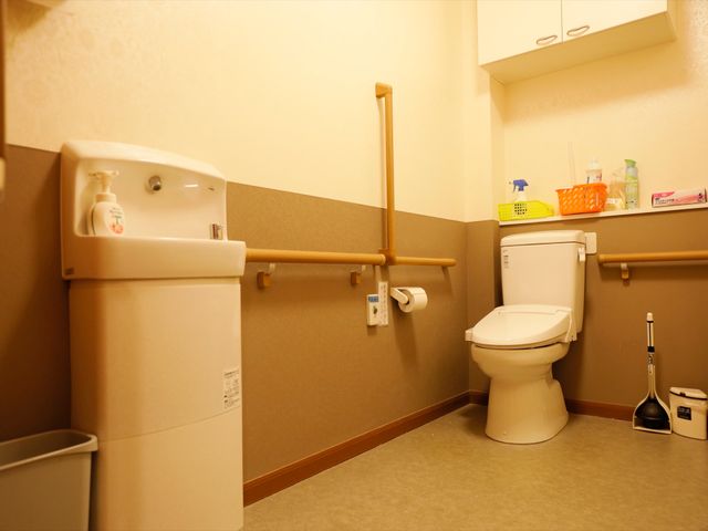 バリアフリー設計のトイレ トイレ 安全に配慮された手すり付きトイレです。清潔感のある環境で、利用者の快適さを重視しています。