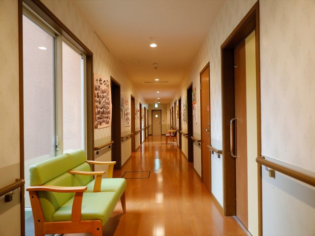 快適な廊下の一角 通路 ゆったりとした廊下には、椅子が設置され、壁にはアートが飾られています。訪れる方への心遣いが感じられる空間です。