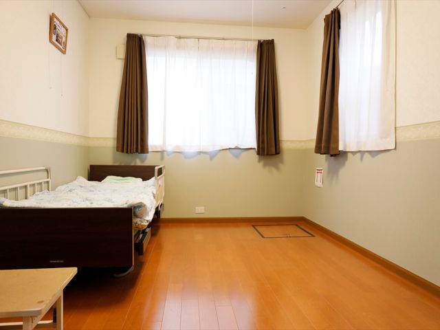 ベッドと床が木目調の居室 居室 木目調の床が心地よい居室です。落ち着いた雰囲気で、ゆったりと過ごせる空間となっています。