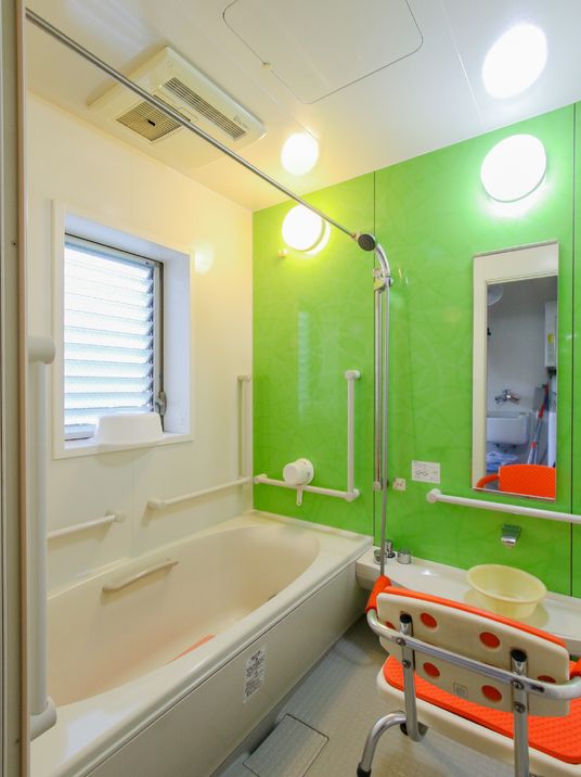 壁に手すりが取り付けられ、バリアフリーが完備されている浴室