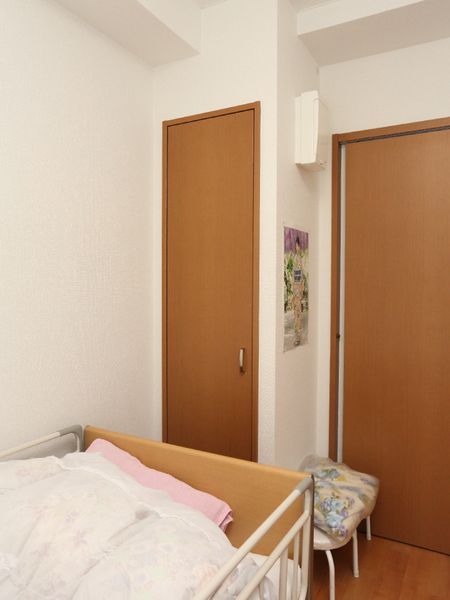ベッドと扉の居室内部