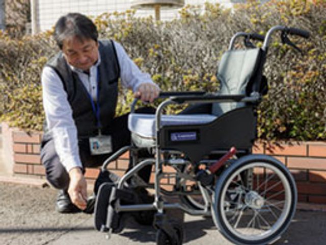 車椅子を調整するスタッフ スタッフイメージ 明るい表情で車椅子の調整をしているスタッフの様子です。利用者の快適を支える心配りが感じられます。