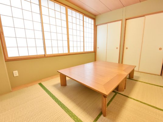 畳が敷かれた和室である。腰高窓には障子が4枚はめ込まれている。部屋の扉は襖になっている。大きな木製の座卓がある。