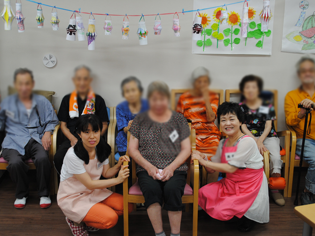 笑顔のグループ集合写真 ラウンジ アットホームな雰囲気の中、にぎやかに笑顔が広がっています。和やかな交流の場になっています。