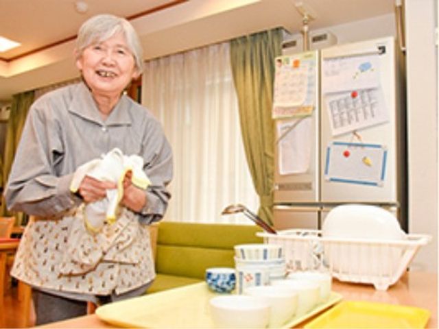 笑顔の高齢女性と生活空間 家事 充実した設備のある明るい居室で、一人ひとりが日々の生活を楽しんでいます。手作業に取り組む笑顔の表情が快適な環境を物語っています。