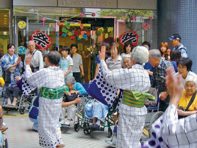 盆踊りを楽しむ人々 浴衣をまとった方々が生き生きと盆踊りを行い、見守る人々の表情からも温かい雰囲気が伝わります。交流を深める活動が積極的に行われており、ここでの仕事が想像できますね。