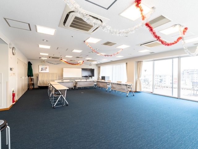 広々とした多目的スペース 共有スペース 明るく開放的な空間で、様々な活動が行えます。窓からは陽光が差し込み、居心地の良い雰囲気を醸し出しています。