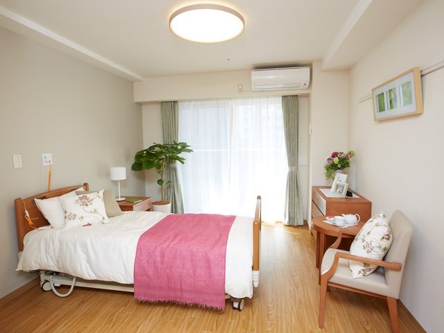 清潔感ある居室空間 居室２ ゆったりとした居室は自然光が入り、心地良い空間を提供しています。日々の生活に必要な家具も整っており、快適な環境でお過ごしいただけます。