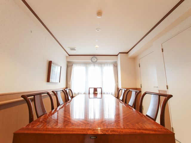 明るい会議室の内観 共有スペース  ゆとりあるスペースの多目的室です。木目調のテーブルが配置され、ディスカッションやアクティビティに最適な環境が整っています。