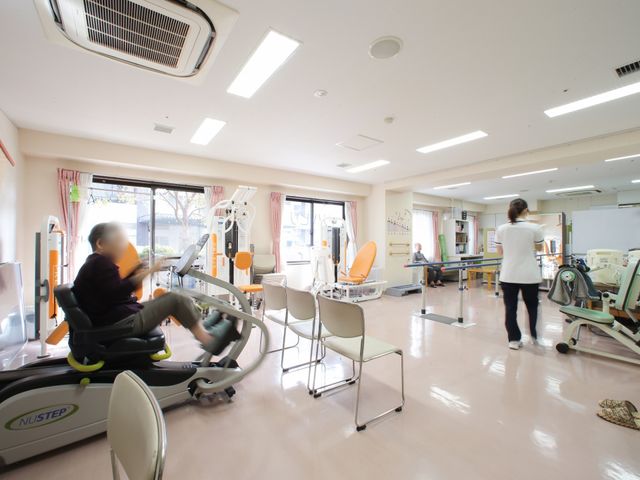 明るい機能訓練室 機能訓練室 広々とした訓練室では、利用者がリハビリ機器を使って健康維持に励んでいます。様々な訓練機器を備え、専門のスタッフがサポートしております。