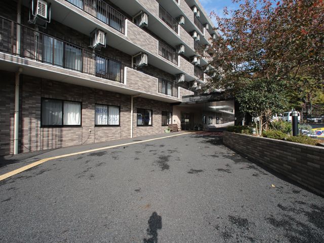 施設の外観とエントランス 外観  ゆったりとしたエントランスが迎える施設で、職員や入居者の笑顔があふれる温かな環境です。複数の窓が光を取り入れ、開放感ある雰囲気が伝わります。