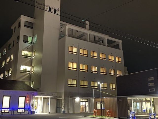 夜景に映る居室のある建物 外観 夜に照らされた建物は、温かみのある光を放ち、訪れる人に安らぎを提供しています。