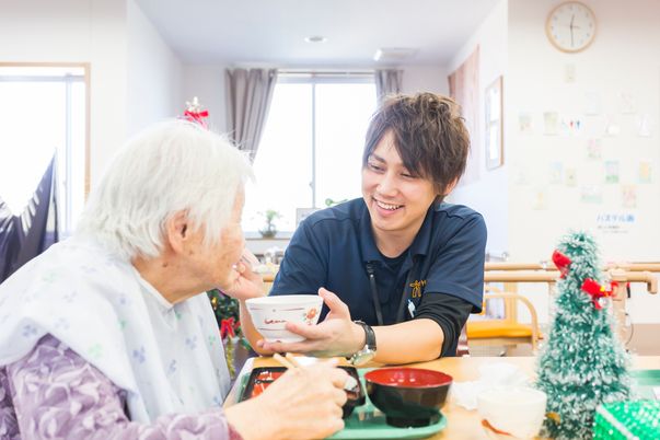 笑顔で食事支援するスタッフ