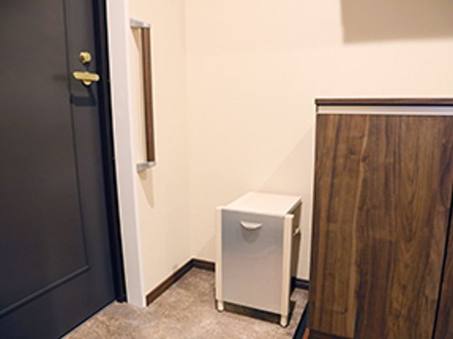 ドアと収納のある部屋 居室   シンプルな収納スペースがあり、落ち着いた雰囲気の室内です。右側には木製のキャビネットがあります。