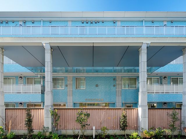 青い外観の建物 外観   青いタイル張りの建物で、庇のある出入口が印象的です。開放感のある外まわりは、働く場としても安心感があります。