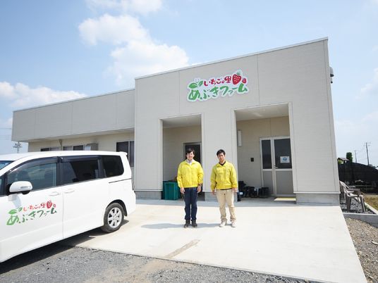 スタッフと車のある外観  