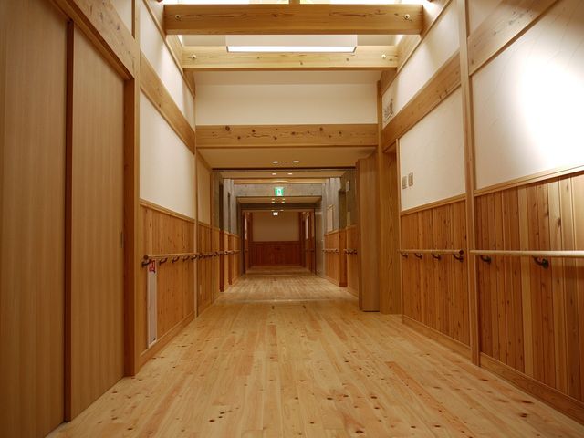 木目調の廊下 廊下   木の温もりが感じられる廊下です。手すりが続いており、移動しやすさに配慮されています。