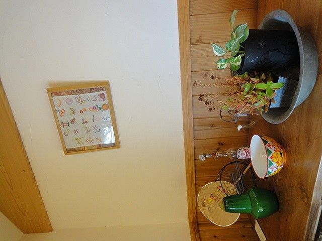 飾り棚のある廊下 廊下   木目の壁に飾り棚があり、花や器が並ぶ落ち着いた空間です。温かみのある雰囲気で、働く場の印象をやわらかく伝えます。