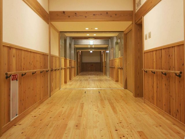 木目調の廊下 廊下   木のぬくもりが感じられる、明るく落ち着いた廊下です。手すりが両側にあり、歩行のしやすさに配慮されています。