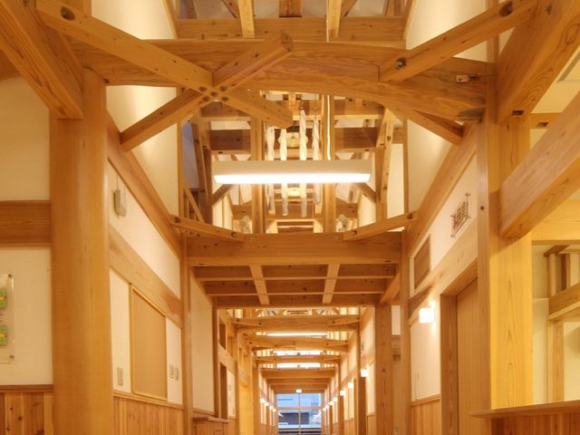 木目調の廊下 廊下   木の梁が印象的な、温かみのある廊下です。奥まで見通せる長い通路で、落ち着いた雰囲気が伝わります。
