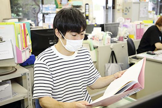 女性が資料を閲覧 スタッフイメージ