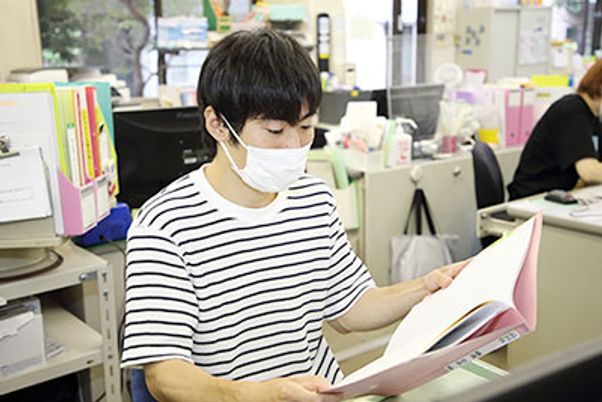 女性が資料を閲覧 スタッフイメージ