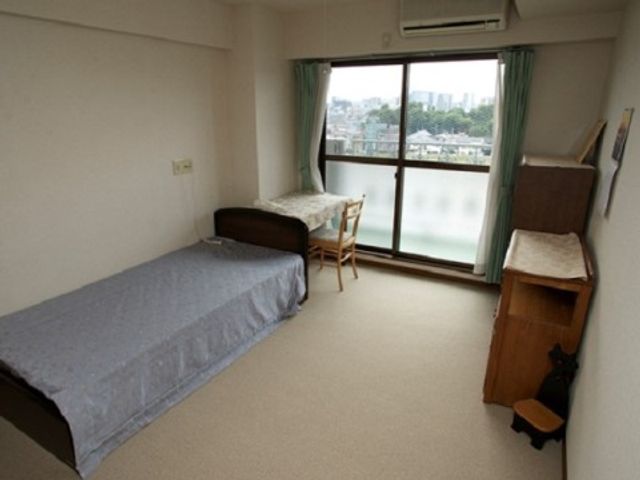 居室のベッドと窓 居室 シンプルな家具と絶景を望む窓が特徴的な居室です。清潔感があり、快適な空間を提供します。
