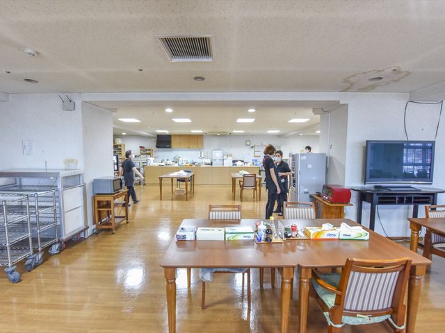 広々とした共有ダイニングエリア 食堂  スタッフの方々が行き交う明るいダイニングスペースです。ご利用者様は広いテーブルで食事や憩いの時間を過ごせます。