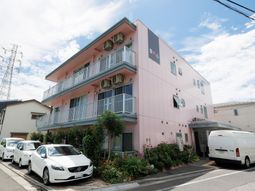 ピンクの建物と駐車場