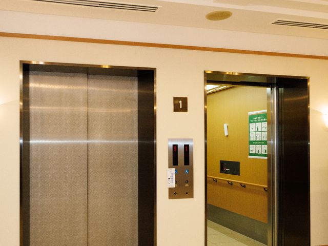 清潔な廊下のエレベーター エレベーター 明るい照明の元、清潔感あふれる移動空間が広がっています。