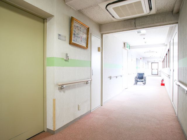バリアフリー対応の廊下 廊下 ゆったりとした空間が広がる廊下は、移動に便利な手すりが整備され、明るい雰囲気が漂っています。車いすも置かれており、アクセスのしやすさが考慮されています。