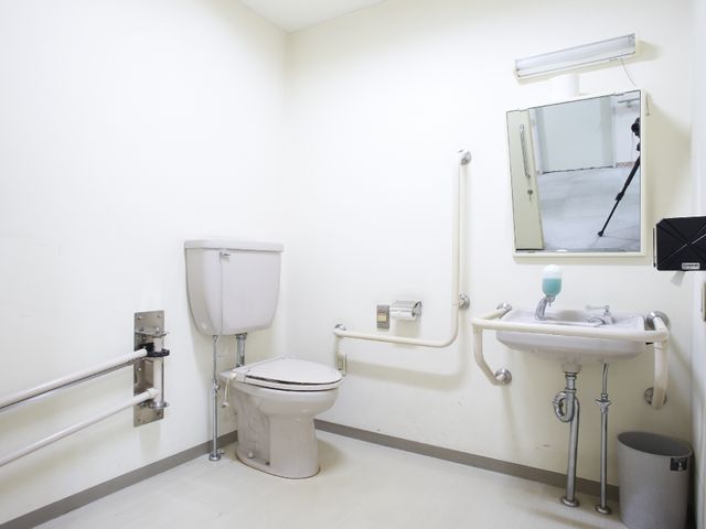 バリアフリー対応のトイレ トイレ 手すり付きで安全に配慮された清潔なトイレスペースです。広々としており、利用しやすい環境が整っています。