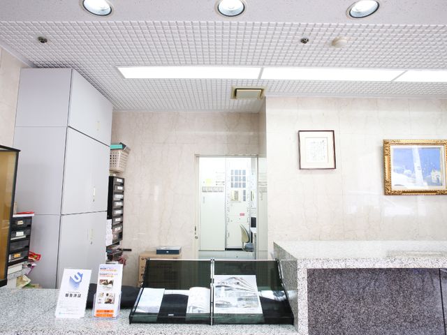 受付カウンターと案内板 受付 整然としたフロントエリアです。必要な情報を提供する案内板が設置され、訪れる方々のサポートを致します。