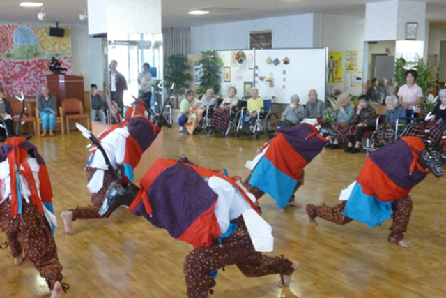 多目的室でのイベント風景 多目的室 広々とした多目的室では、色とりどりの衣装をまとった方々が楽しげなパフォーマンスを披露しており、見守る皆さんの笑顔が印象的です。