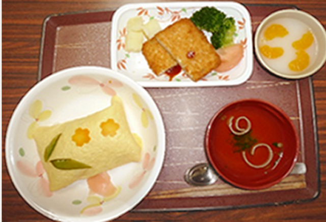 手厚いケアの食事サービス 食堂 温かみのある食事が配置された食事スペースです。栄養バランスも考えられた美味しそうな食事をご用意しています。