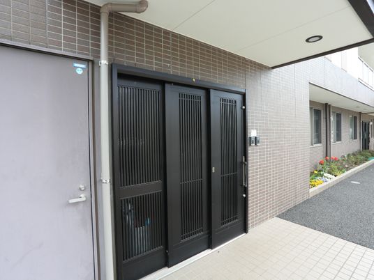 玄関は大きく開くドアが特徴。車いすや歩行器でも出入りしやすい。屋根が張り出しているため、建物から出たら即濡れることもなく便利。