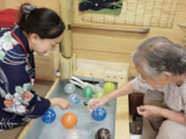 目の前のスタッフの笑顔の様子 スタッフイメージ 和やかな雰囲気の中で、スタッフが利用者さんと一緒に楽しむ活動の様子です。