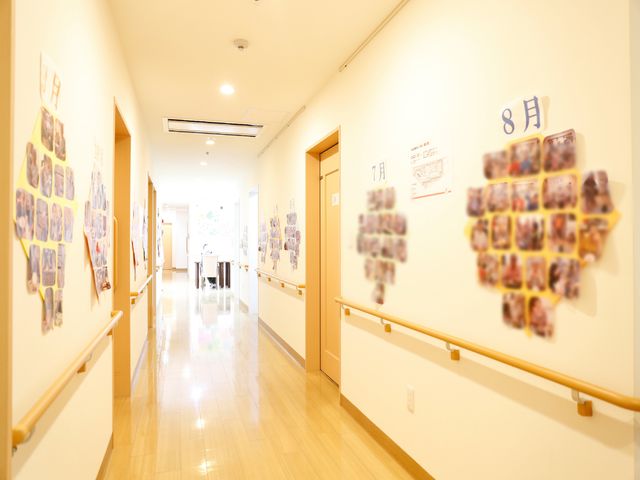 暖かみのある廊下の様子 廊下の壁には利用者さんの写真 温かな雰囲気の廊下には、壁に季節のイベントの写真が飾られ、訪れる人々にアットホームな印象を与えます。
