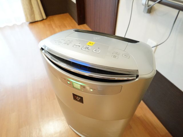 洗濯機のクローズアップ 空気清浄機 最新設備のコインランドリーで、清潔な衣類を保てます。快適な生活環境づくりに貢献します。