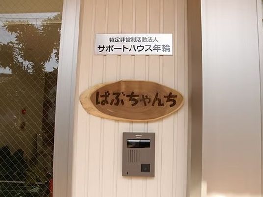 施設名看板のある玄関前  