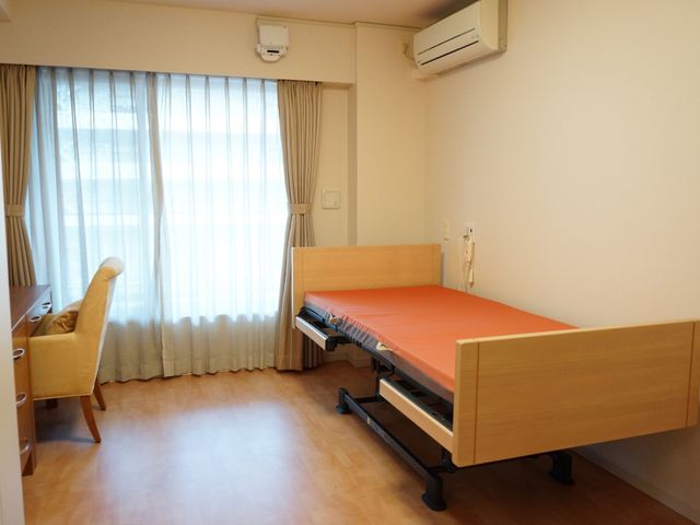 明るい個室の居室 居室 清潔感のあふれる居室で、大きな窓からの自然光が心地よく差し込んでいます。必要な家具が整えられ、静かで快適な個人のスペースを提供しております。